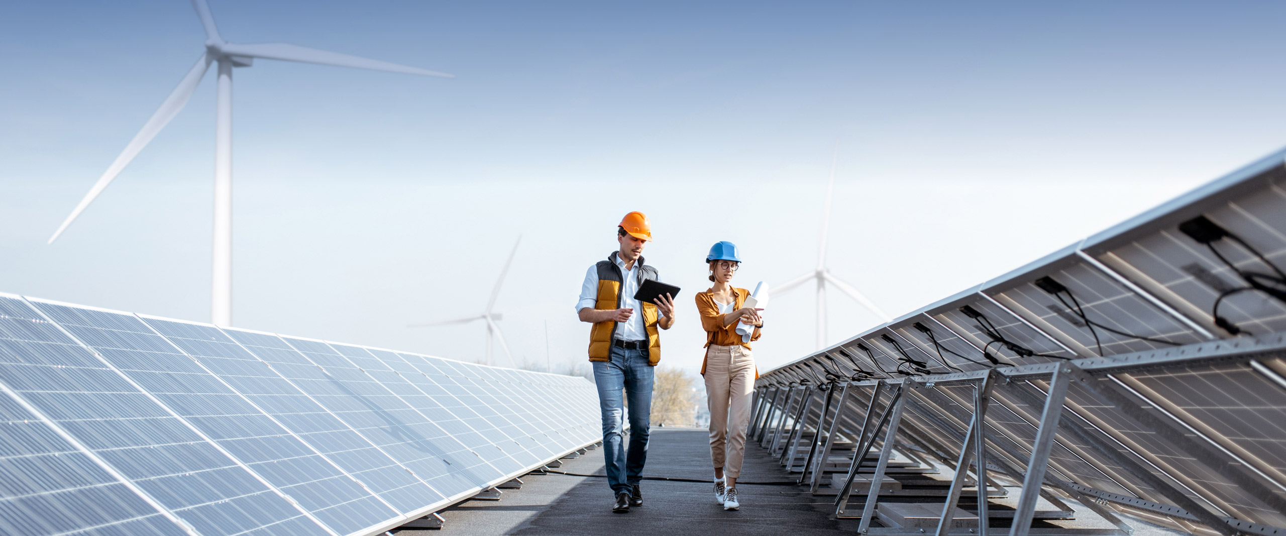 Jetzt Ansprechpartner finde und Kontakt aufnehmen Frau und Mann, die durch eine Solar-Anlage gehen